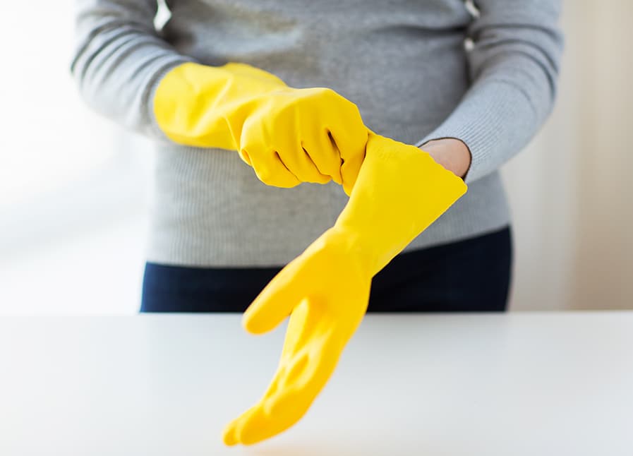 Mãos com luvas de látex em cor amarela